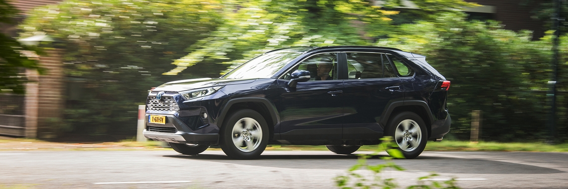 Toyota-exterieur-RAV4-rijdend-zijaanzicht-bomen